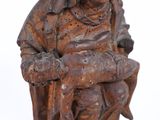 a wooden statue of a man holding a child