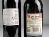 two bottles of wine sitting next to each other on a table
