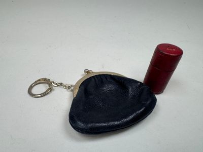 un petit sac à main noir contenant un rouge à lèvres rouge