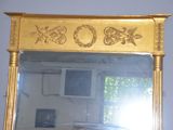 a mirror that has a gold frame on it