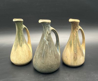 three vases are sitting on a table with a black background