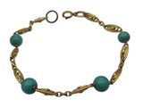 un gros plan d'un bracelet orné de perles vertes sur fond blanc