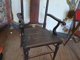 a wooden chair sitting in a room with a wallpapered wall
