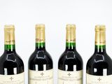 three bottles of red wine are lined up on a table