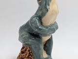 ceramic figurine of a frog sitting on a tree stump