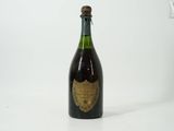an old bottle of champagne sitting on top of a white table