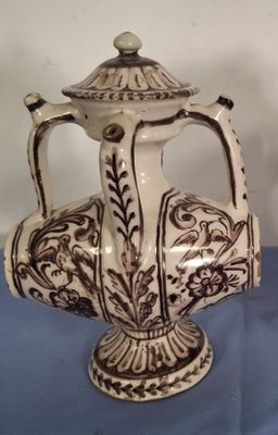un vase marron et blanc posé sur une table bleue