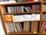 a wooden bookcase filled with vinyl records and cds