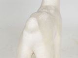 a white sheep statue sitting on a white surface