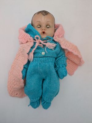 a doll that is laying down on a white surface