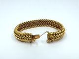 a gold bracelet on a white background