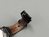 a close up of a watch with a leather band on a table