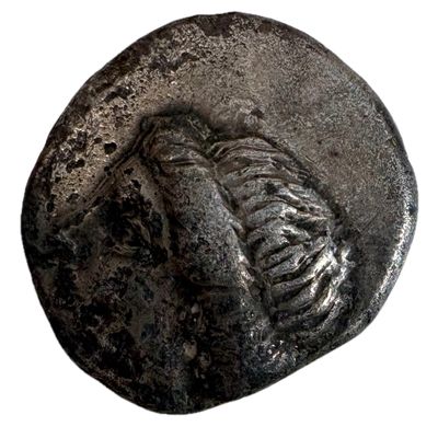 une pièce de monnaie ancienne représentant un squelette sur fond blanc