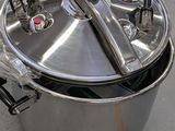a large metal pot with a handle on the ground