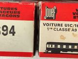 two boxes of red and white train cars on a shelf