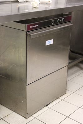 un grand lave-vaisselle en acier inoxydable dans une cuisine professionnelle