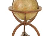 un vieux globe terrestre posé sur un socle en bois, sur fond blanc