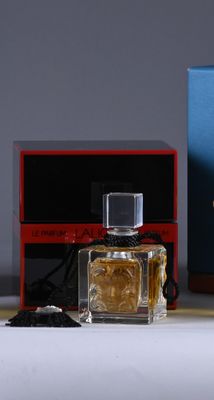 a bottle of perfume next to a box on a table