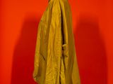 yellow raincoat on a mannequin stand against a red wall