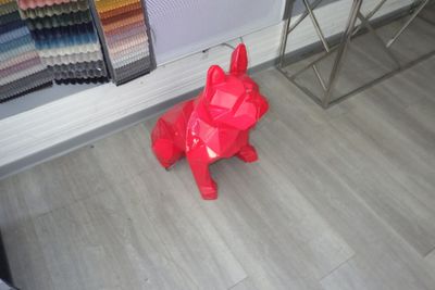 un chien en origami rouge, assis par terre