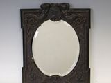 un miroir ancien en bois, doté d'un cadre sculpté sur un fond blanc