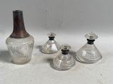 trois vases en verre et une bouteille posés sur une table