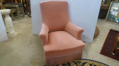 une chaise rose ornée de franges dans une pièce