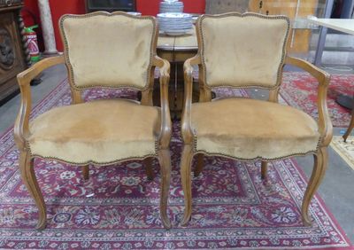 pair of upholstered chairs in a room with a rug on the floor