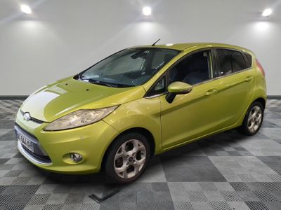 a lime colored ford fiesta parked in a garage