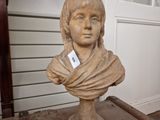 a statue of a woman with a scarf on a table