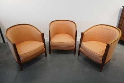 trois chaises orange placées dans une pièce, à côté d'une commode
