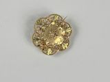 une image représentant une broche en or ornée d'un visage de femme