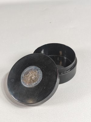 un petit récipient en métal contenant une pièce de monnaie