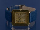 an image of a wrist watch on a blue surface