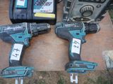 two cordless drillets sitting on a table next to other tools