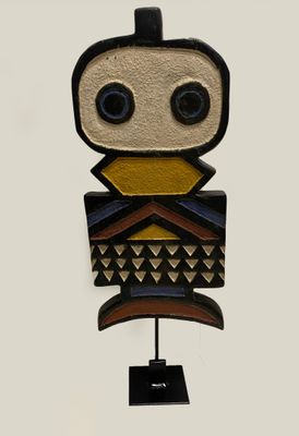 a close up of a wooden sculpture of an owl on a stand