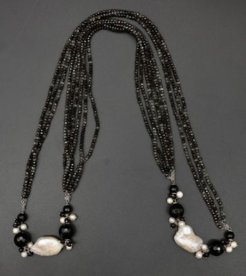 un collier en perles noir et blanc, composé de perles et de perles noires