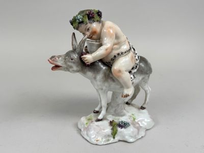 a figurine of a boy riding a donkey
