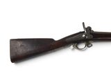 un vieux fusil avec un canon en bois et des garnitures en laiton