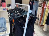 a rack of clothes in a clothing store with clothes on hangers