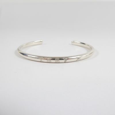 a close up of a silver cuff bracelet with diamonds on it