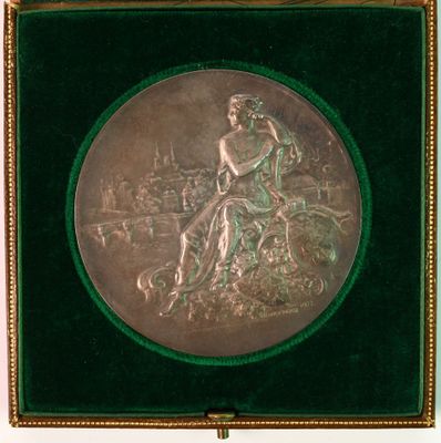 an antique silver plate with a woman sitting on top of a tree