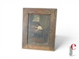 an old picture of a woman sitting at a table in front of a window