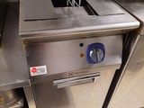 plan de travail en acier inoxydable dans une cuisine professionnelle, avec une friteuse sur le côté