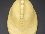 a close up of a yellow helmet on a black surface