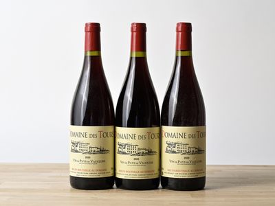 trois bouteilles de vin posées sur une table en bois