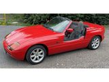une photo d'une voiture de sport rouge garée sur un parking