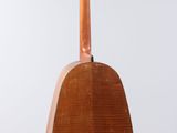 an old guitar hanging from the back of a wooden stand