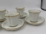 six white and gold coffee cups and saucers sitting on a table