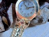 une montre en argent posée sur un bracelet en argent